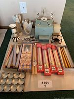 Overview of candles in boxes, loose tapers, tealights, and various candle holders on display