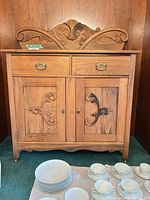 Front view of oak sideboard showing drawers, doors, carved crest