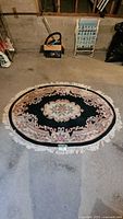 Full view of oval floral rug with fringe