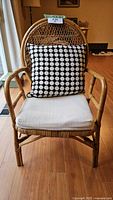 Front view of rattan armchair with cushion and pillow
