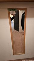 Front view of full length mirror mounted on wall