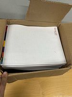 Open box filled with stacked Gescan grid paper pads