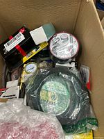 Overview of box showing belts, gauges, sanding sponge and misc items