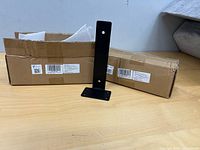Two cardboard boxes labeled model C74019 with one black steel floating shelf bracket displayed