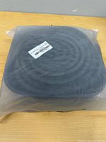 Sealed plastic bag with coiled black rubber seal visible