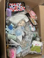 Top view of box showing multiple individually bagged phone cases and earbud covers