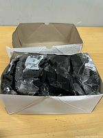 Open cardboard box showing multiple individually wrapped safety glasses