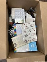 Top view of box showing calculator, sticker sheet, index dividers, spray can
