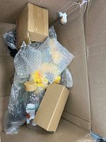 Overall view of box showing drink bottle, bubble-wrapped items, small cartons