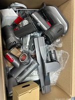 Dyson vacuum attachments piled inside box