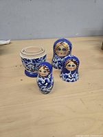 Three assembled dolls plus largest separated shell on tabletop