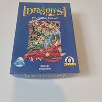 Front of Dragon's Gold box showing title, artwork, designer credit, Blue Games and Descartes logos