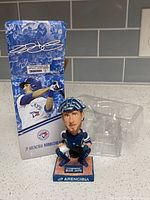 Bobblehead in front of original box and plastic insert