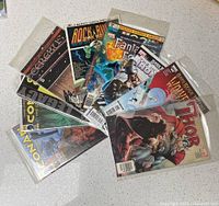 Overview of all ten comic books fanned out on table
