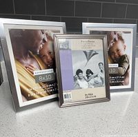 Three silver-tone 8x10 frames standing on countertop
