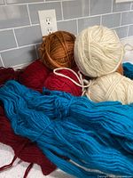 Assorted balls and skeins of coloured wool on counter