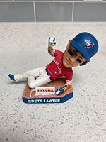 Bobblehead lying on textured counter showing base with name