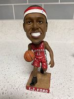 Front view of TJ Ford Raptors bobblehead showing uniform, basketball, base label