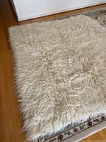 Full view of cream Flokati rug on floor