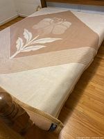 Blanket spread on bed showing floral pattern and colour