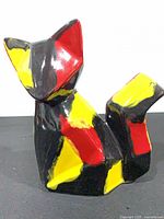 Front view of angular ceramic fox with black, red, yellow glaze