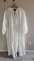 Full view of off-white long Birgitte Herskind dress on hanger