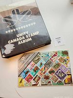 Closed Unity Canada Stamp Album binder and loose stock card filled with colourful stamps