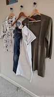 Four garments hung: blue jeans, white jeans, Gap shirt, green cardigan