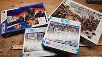 Group image of four boxed 1000-piece puzzles displayed on tabletop