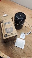 Mosquito trap device with box, USB cable and manual on table