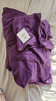 Folded purple bamboo sheets with lot tag, showing color and fabric texture
