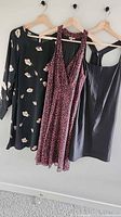 Three dresses hanging on wooden hangers
