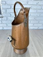 right side view showing full copper pitcher with side porcelain handle and top handle