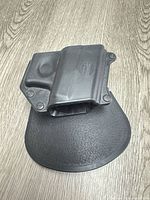 Front view of black Fobus polymer holster on paddle
