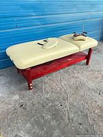 Full view of massage table with accessories on top, showing overall condition