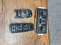 Three automotive control modules displayed on wooden floor