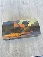 Top view showing rooster image on curved lid