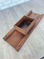 Full view of wooden cabbage slicer with hopper attached