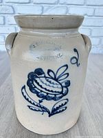 Front view of jug showing floral cobalt decoration and maker stamp