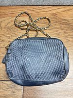 Front view of black quilted Worthington purse showing diamond stitching and chain strap