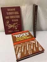 Three woodworking books upright and flat showing covers and spine