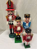 Group shot of four wooden nutcrackers showing relative sizes and colors