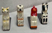 Front view of the four wooden animal doorstops in a row
