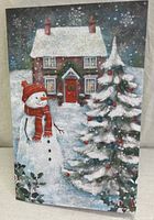 Front cover of one card depicting snowman, house, decorated tree