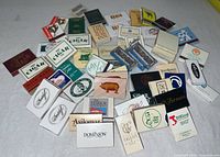 Wide view of entire assortment of matchbooks spread on surface