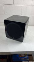 Front view of black Episode subwoofer showing grille and glossy finish