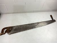 Full view of Disston two-person crosscut saw showing entire blade and both handles