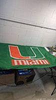 Full view of green University of Miami flag on table