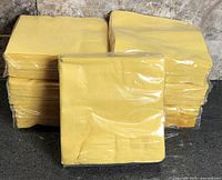 Stack of seven sealed yellow napkin packs