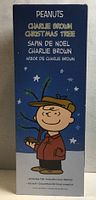 Front of Peanuts Charlie Brown Christmas Tree box showing cartoon Charlie Brown holding tree